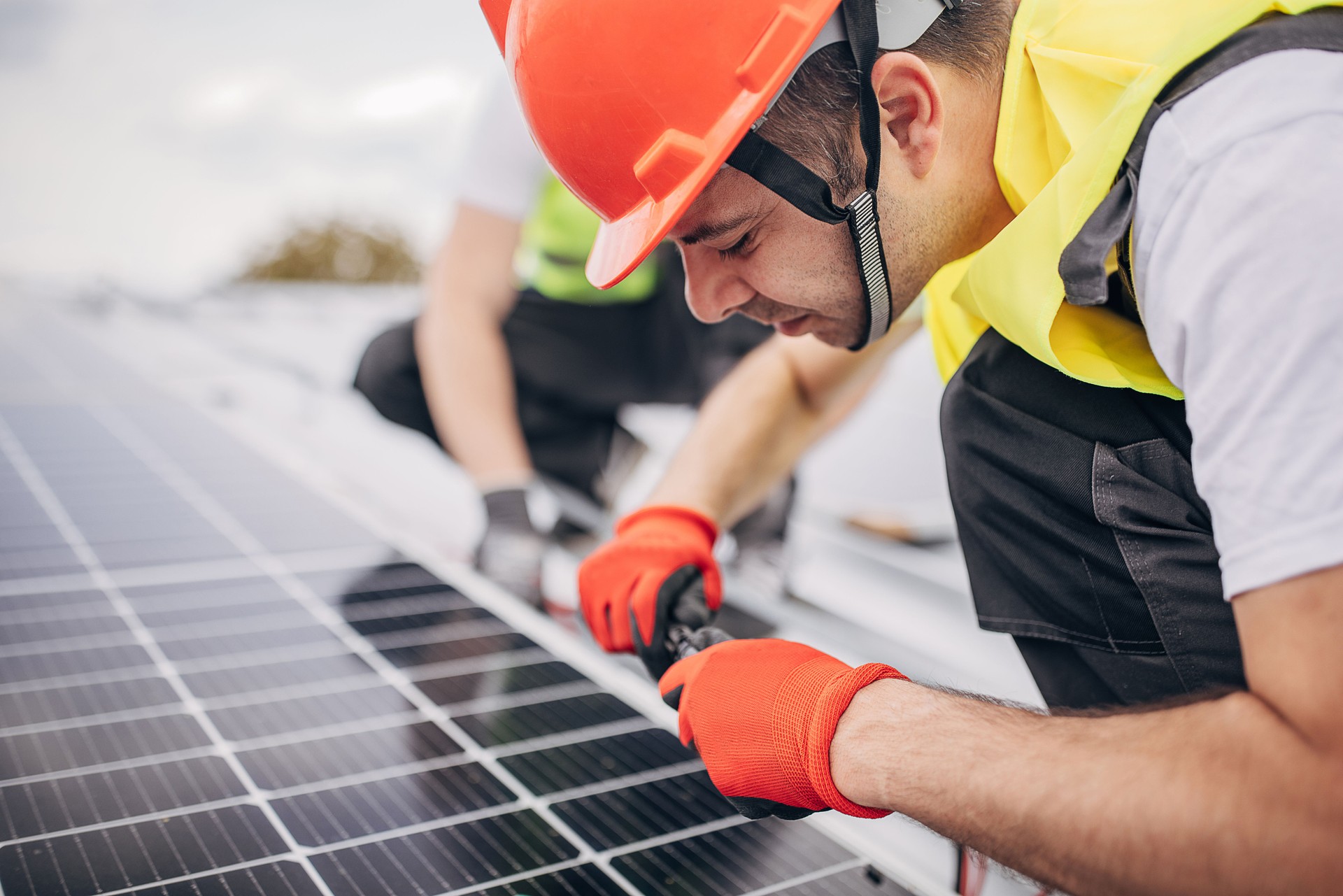 Arbeiter, die Sonnenkollektoren installieren